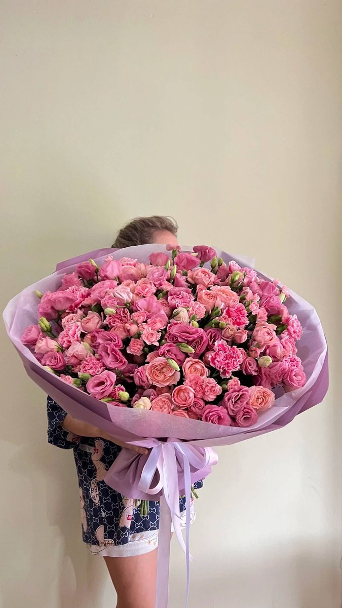 A large lush bouquet of pink peony and spray roses with carnations in lilac wrapping — flower delivery in Antalya